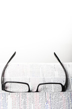 reading glasses on the pages of a Bible - searching for clarity