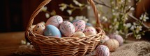 Easter eggs in a wicker basket on a wooden background.