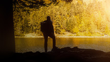 hiker standing next to an autumn lake 