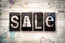 word sale on a white wash wood background 