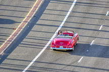 a red vintage convertible driving down the Pacific Coast highway