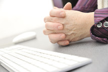Hands of an old female typing on the keyboard
