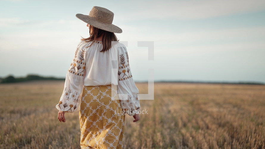 Portrait of ukrainian woman in wheat field after harvesting. Attractive cheerful lady in embroidery vyshyvanka blouse and straw hat. Ukraine, independence, freedom, patriot symbol, charming girl