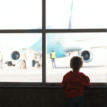 Boy looks at the plane at the airport