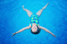girl floating on her back in water 