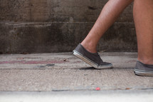feet walking on a sidewalk 