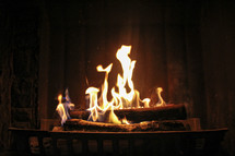 flames on logs in a fireplace 