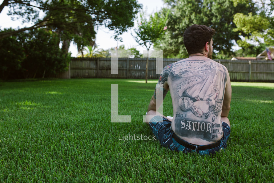 man with religious tattoos on his back 