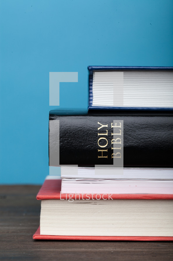 A Bible in a stack of books.