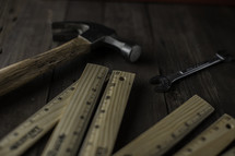 rulers, hammer, and wrench on a workbench 