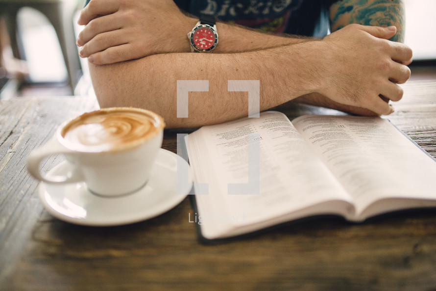 cappuccino and a man reading a Bible in a coffee shop 