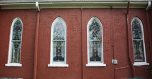 stained glass windows on a brick church 