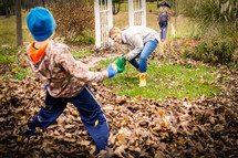 kids playing in fall leaves 