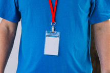 Torso of a man in a blank blue tshirt wearing a lanyard.