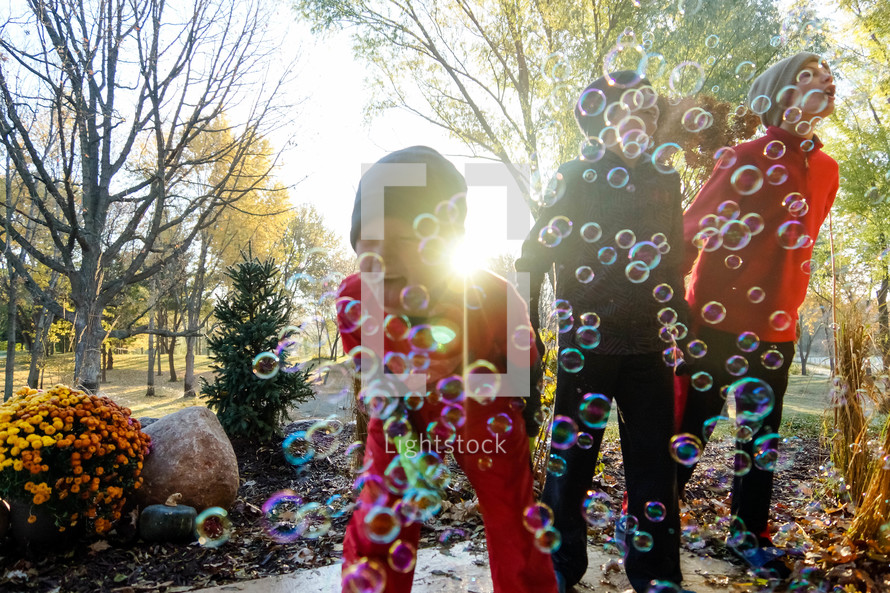 children playing with bubbles in fall 