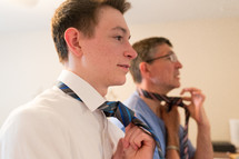 father and son putting on neckties 