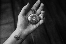 hand holding a pocket watch 
