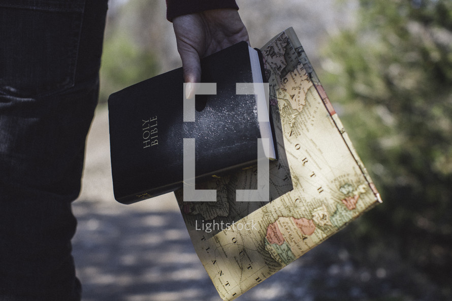 man holding a Bible and world map 