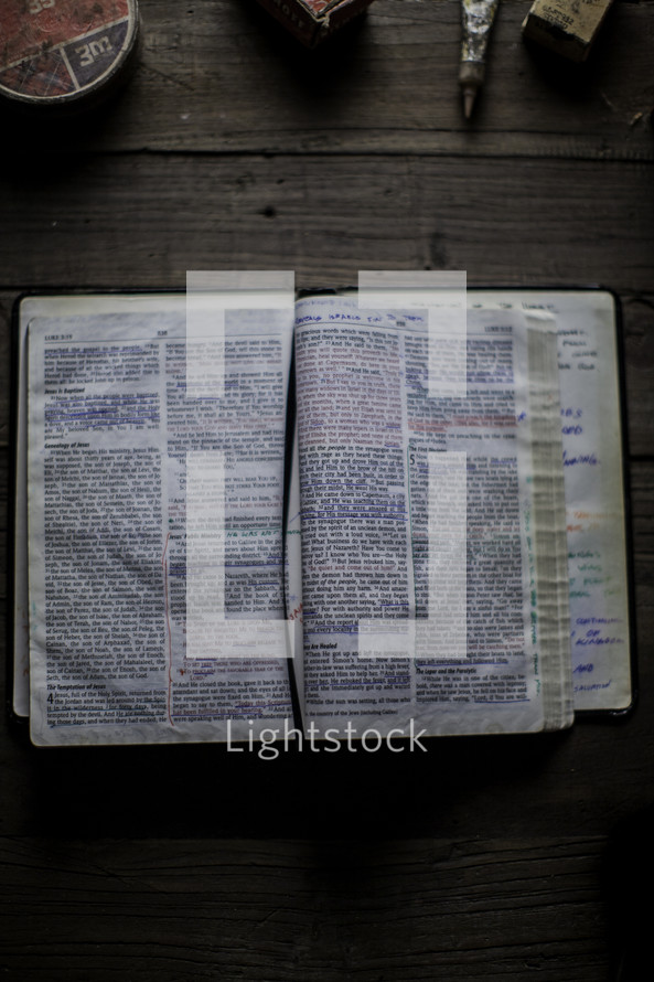 notes on the pages of a Bible on a workbench 