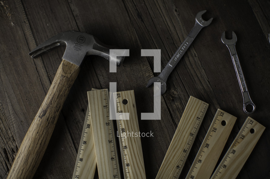 hammer, wrench, and rulers on a workbench 