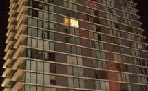 apartment building at night with one single lit window