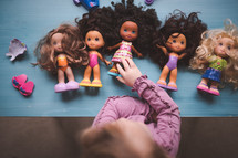 little girl playing with dolls 