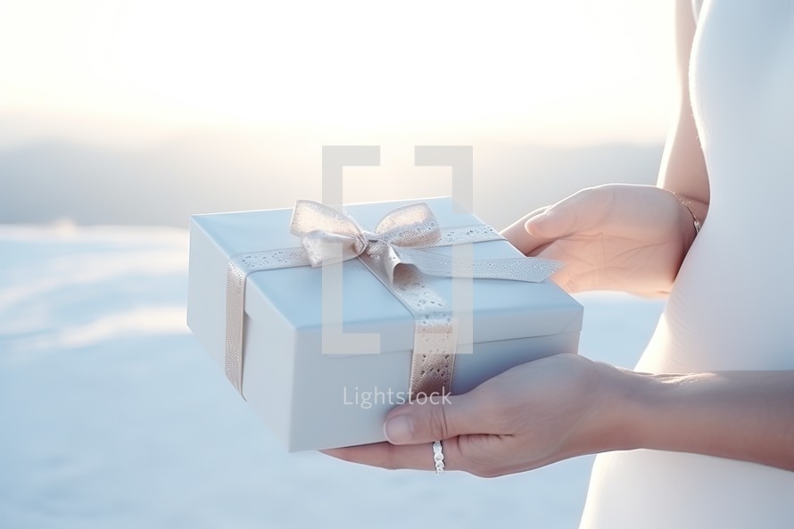 gift box in the hands of a woman on the background of the winter landscape