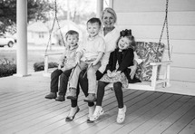 grandmother on a porch swing with her grandchildren 