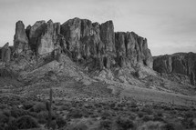 A massive rock formation in the desert.  Black and white.