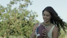 a young woman catching and throwing a football 