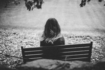 woman sitting on a park bench alone