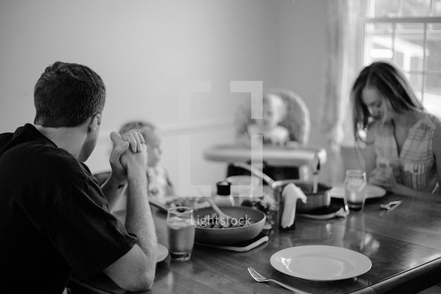 a family saying grace before a meal 