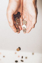 cupped hands pouring out coins