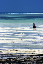woman standing on a white sand beach, Masai in Zanzibar