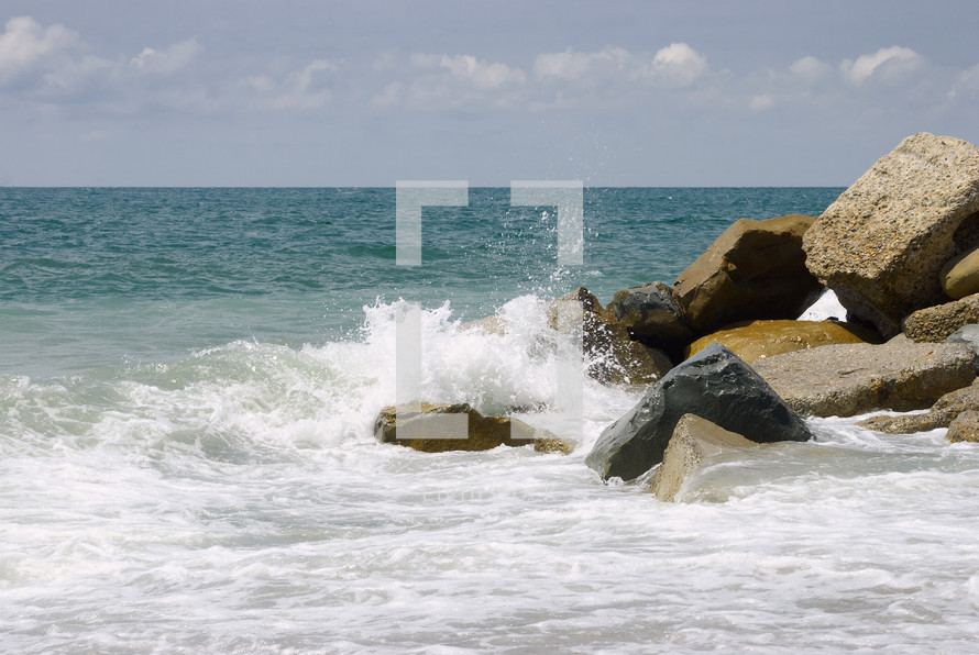 seascape with background for text. Scenic beautiful morning surf on the rocky shore under cloudy heaven