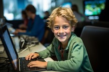 A young boy engrossed in his work, focused on the laptop in front of him