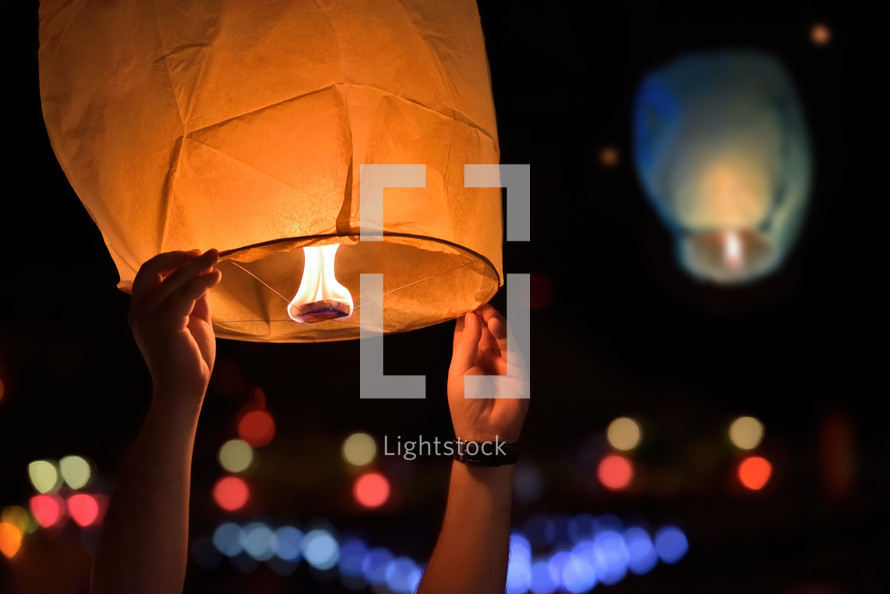 Releasing a paper lantern in the night sky
