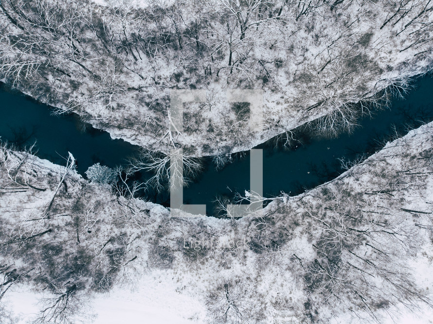 aerial view over a river and snow covered landscape 