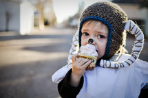 boy child in a ram costume eating a cupcake 