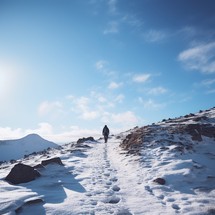 Man conquering snow-covered mountain, just two steps from the top