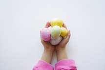 cupped hands holding Easter eggs 
