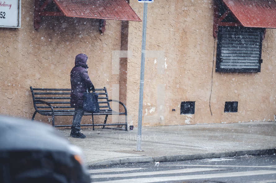 a person standing outdoors on side walk in winter 