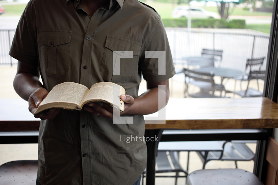Hands holding an open Bible.