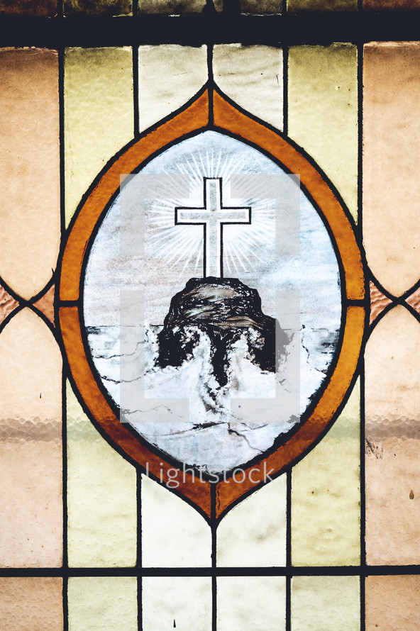cross on a rock at sea stained glass window 