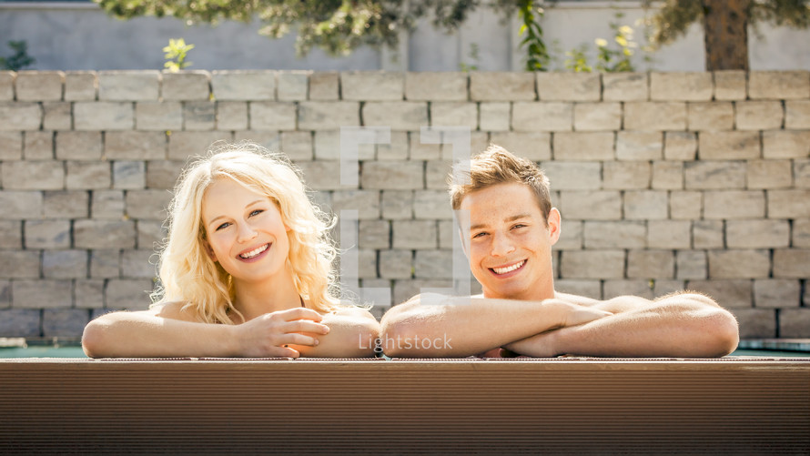 young couple at the edge of a pool 