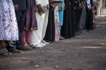 feet of family members gathered at a graduation ceremony in Africa 