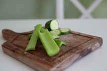 celery and cucumbers on a cutting board 