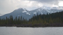 lake in front of snow covered mountain peaks 