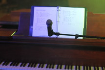 Music notes and microphone at a piano.