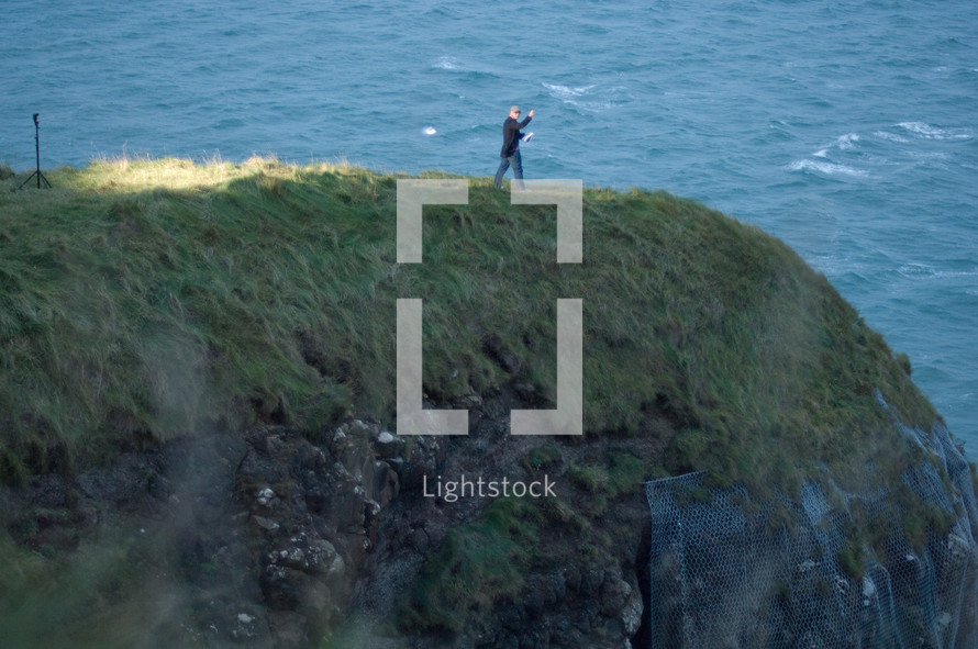 man standing near the edge of a sea cliff 